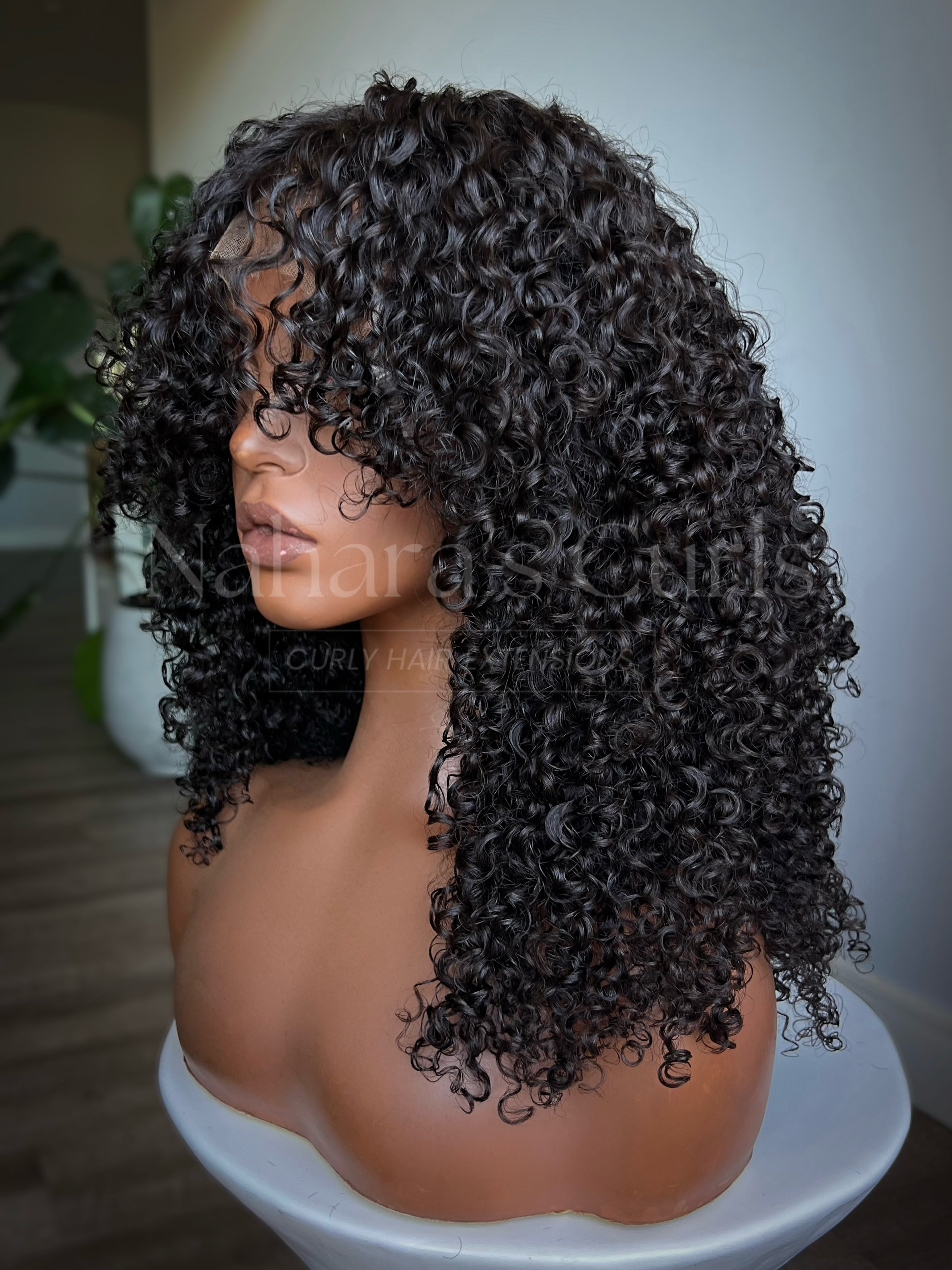 Back view of medium-length curly wig showing layered shag haircut and defined curl pattern
