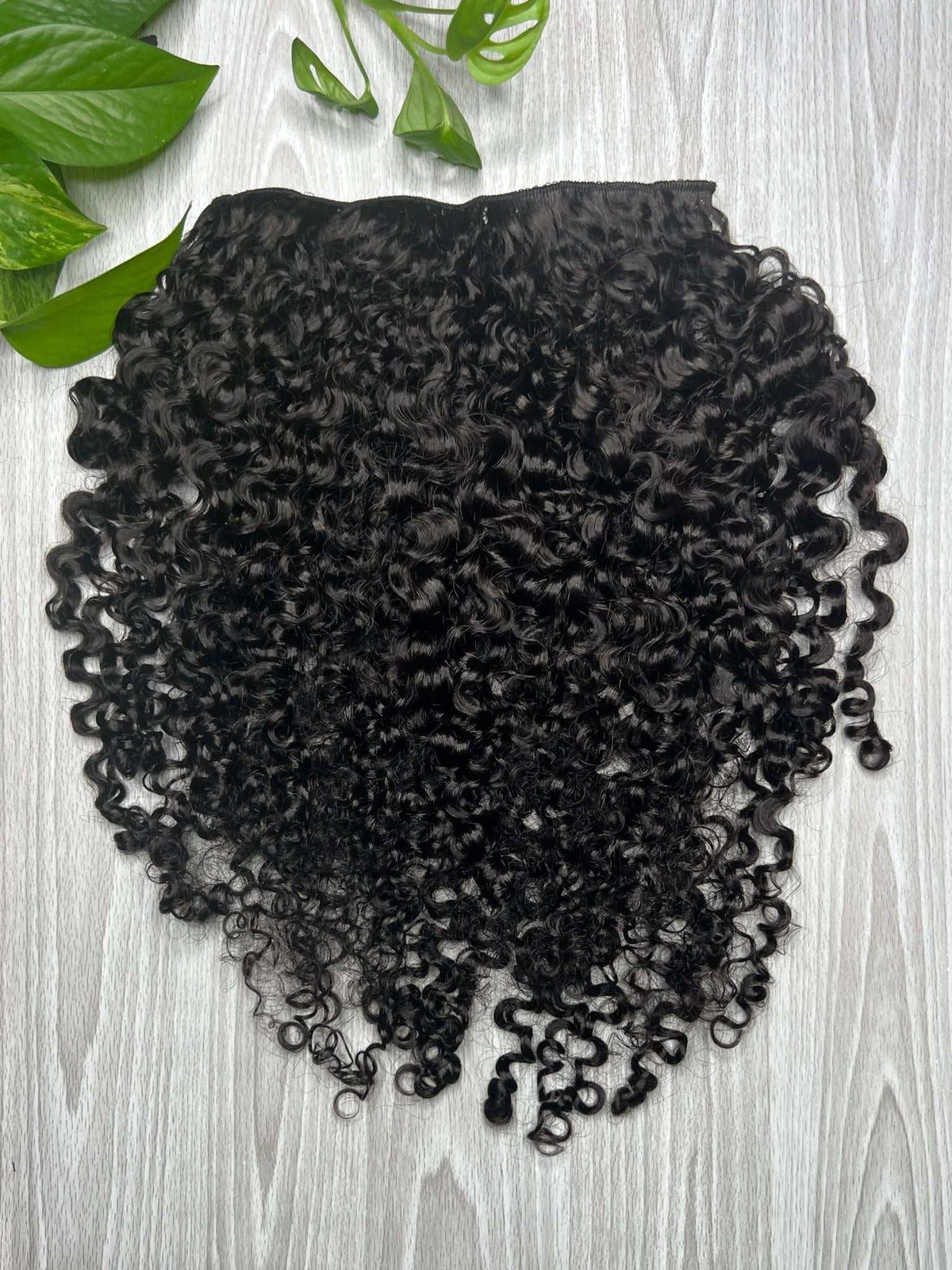 Full set of Amala loose curl clip-in extensions with soft, fluffy curls