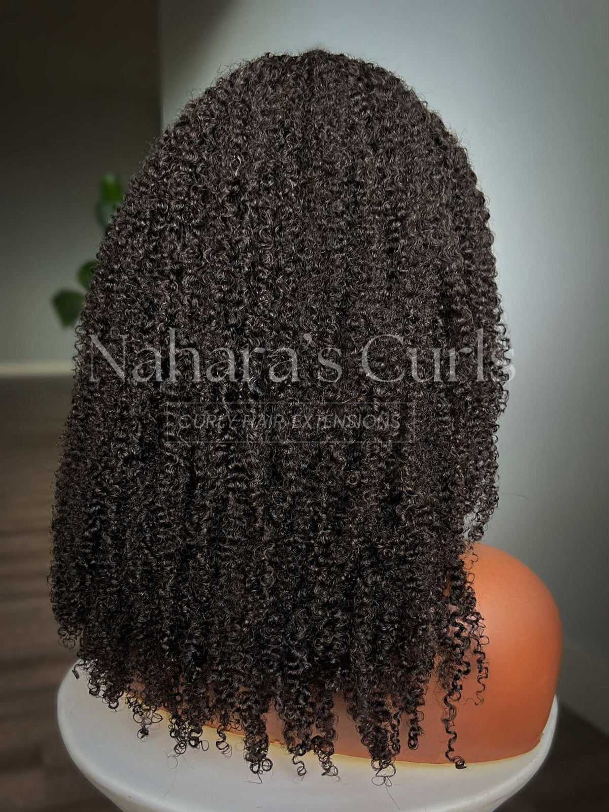 Aura kinky curls from the back, showing how the curls stack from root to ends