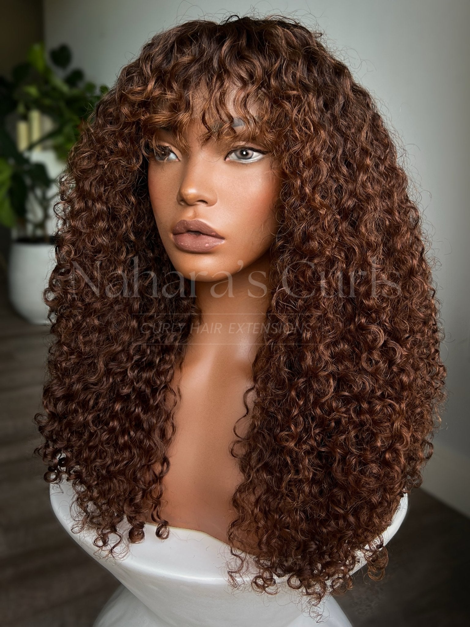 Wet and wavy human hair wig featuring boho curls, dimensional copper brown balayage, and face-framing bangs