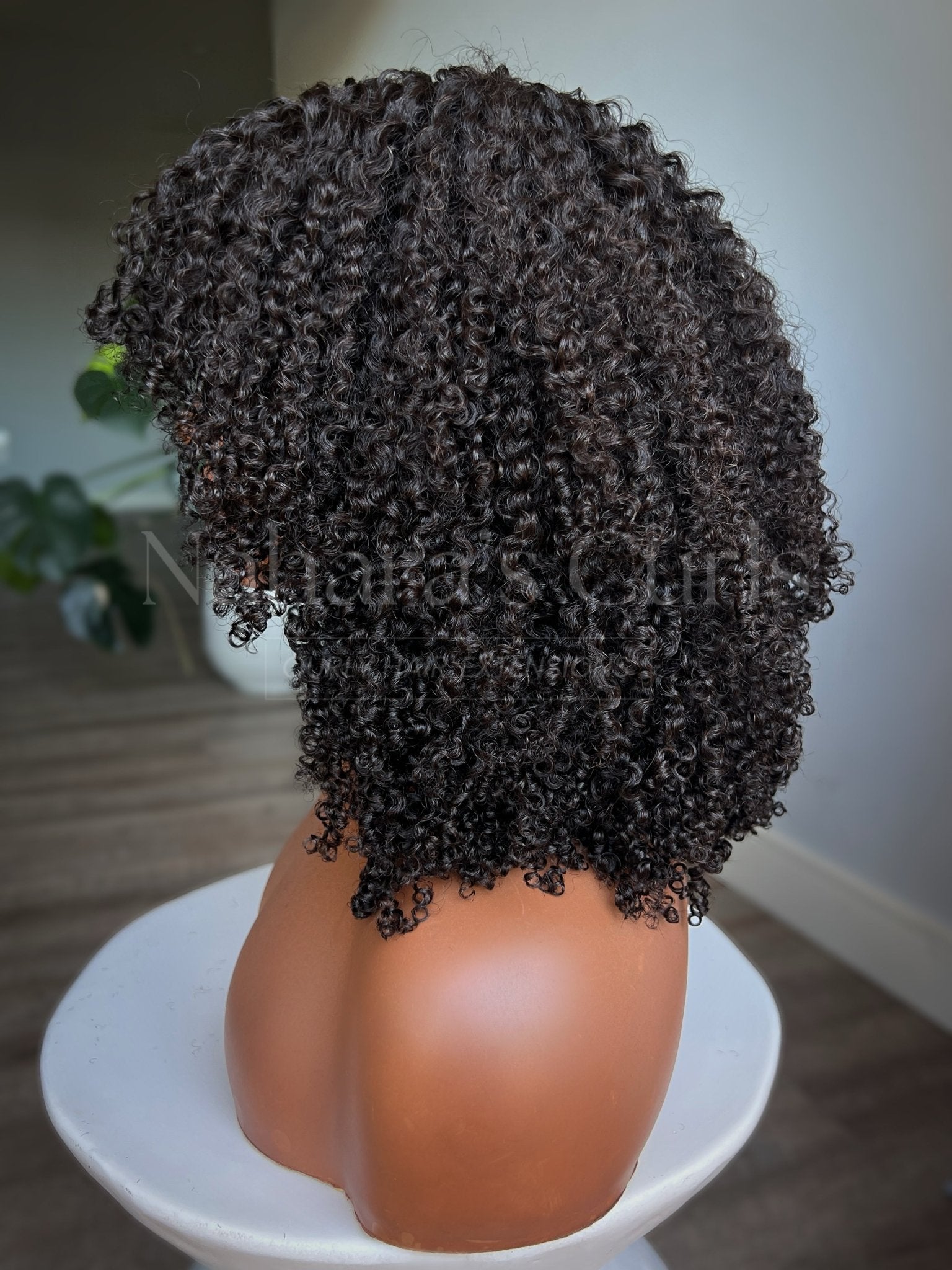 Side view of medium length coily human hair wig with natural textured curls