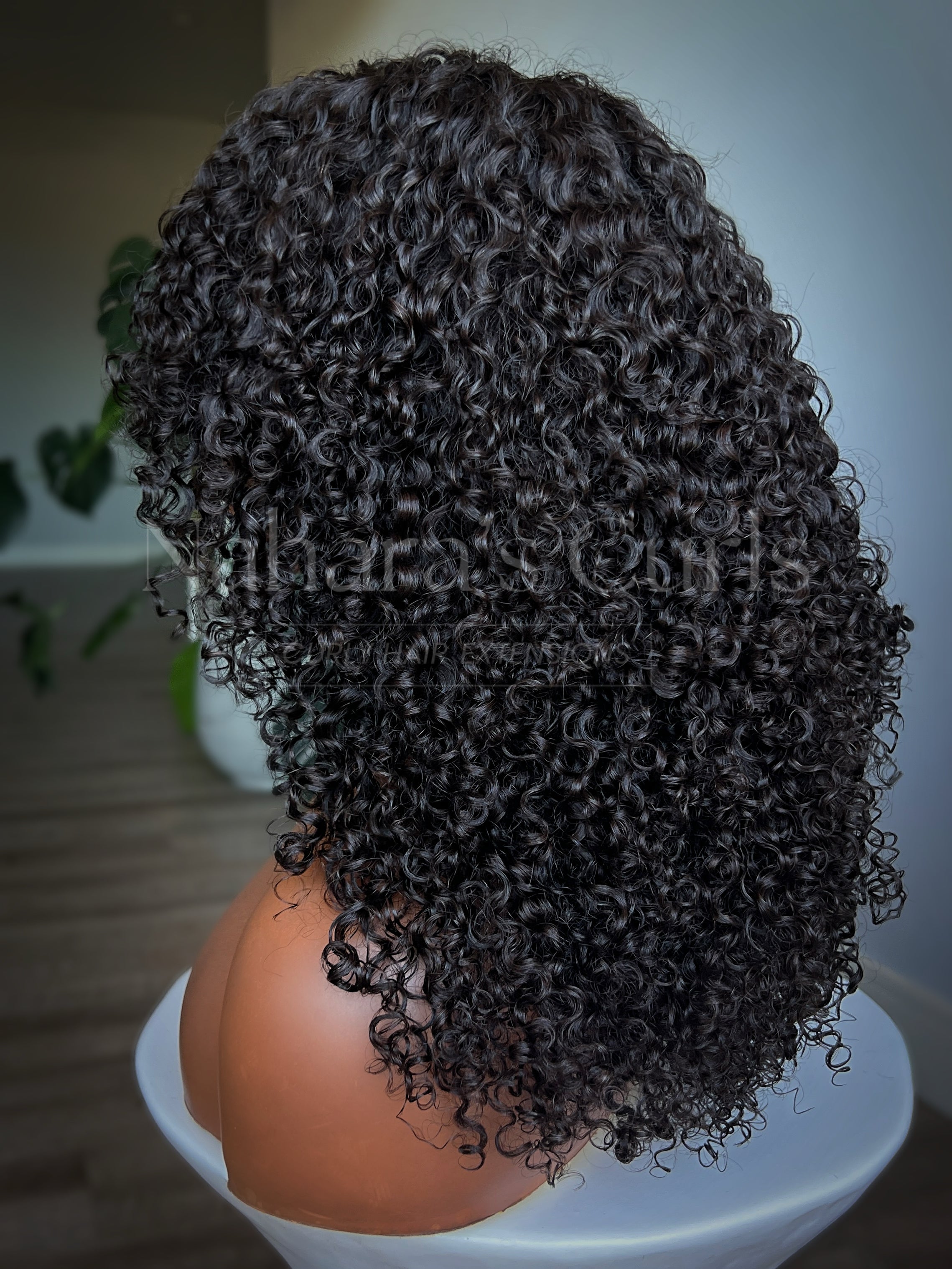 Natural-looking curly human hair wig with layered shag cut and full, defined Burmese curls
