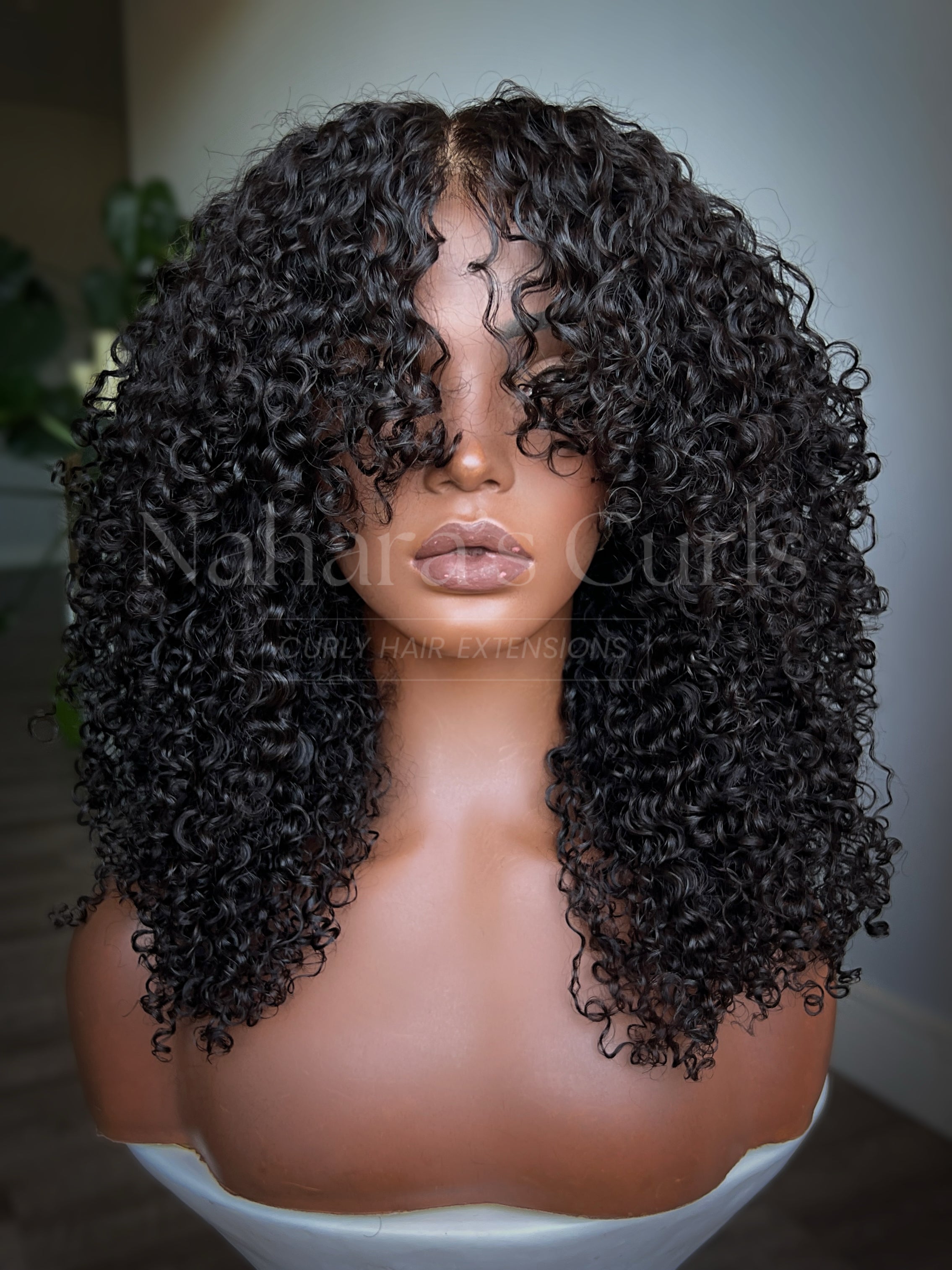 Side view of layered curly human hair wig with soft Burmese curls and face-framing shag layers
