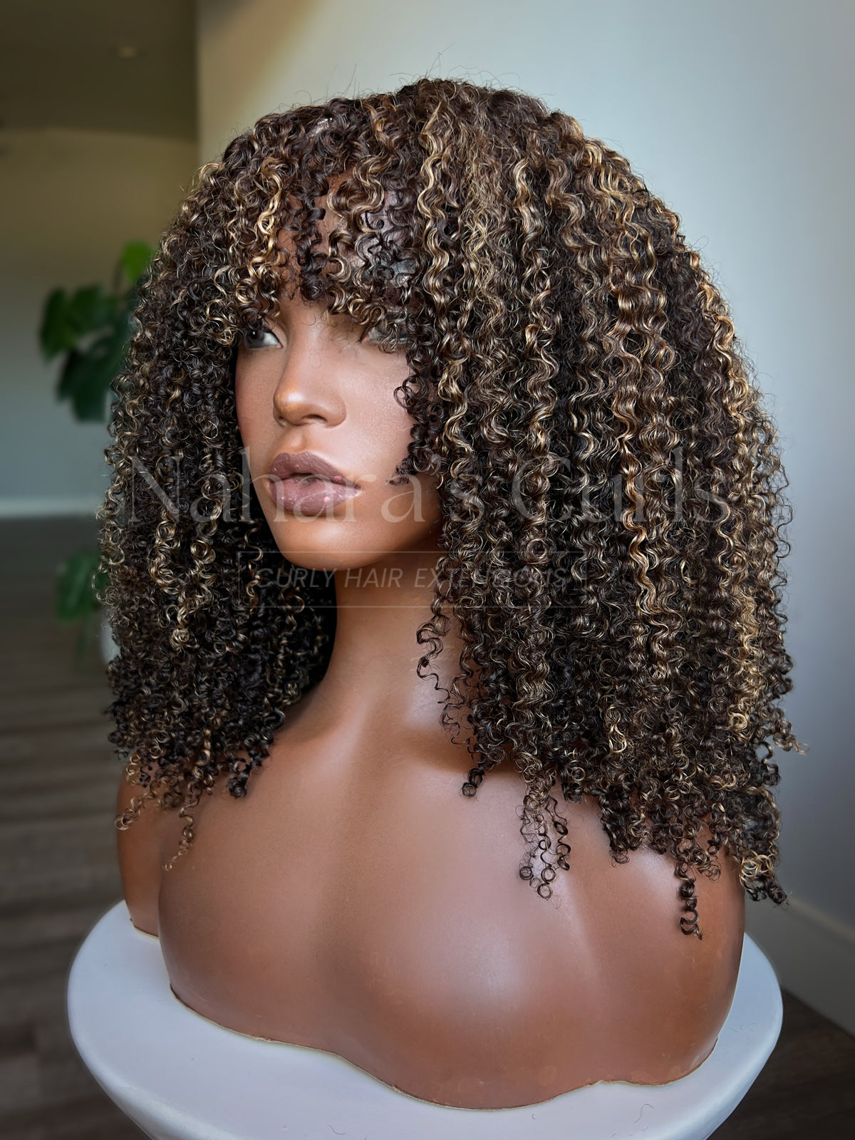 Brown kinky curly U-part wig with honey blonde highlights and natural volume, angled front view