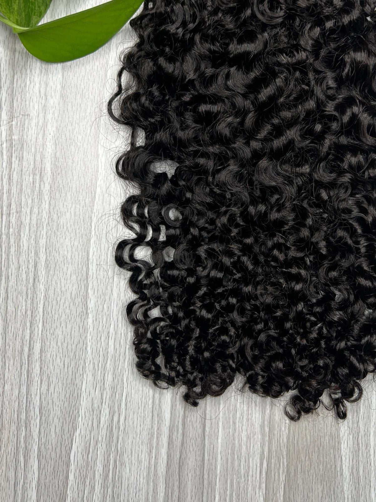 Amala Clip-Ins hanging to show length and natural curl movement